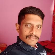 A close-up, high-quality portrait of a stylish Indian young man. He has  well-styled, voluminous dark hair . He is wearing a pastel lavender  crewneck sweater with the name 'Giriraj'embroidered in purple. He