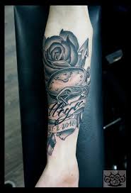 In the past, rose tattoos symbolized very specific meanings, usually inked as a tribute to a loved one, a spouse or a child. Grey Ink Memorial Pocket Watch And Rose Tattoo With Name And Date Banner By Marco Knox