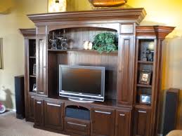 It features four doors with shelving inside for storage and black. Entertainment Centers Fiorenza Custom Woodworking