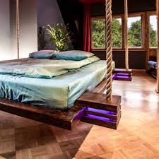 A stained wooden hanging bench or bed with pillows and cushions is a cool piece for outdoor relaxation. Hanging Beds Posts Facebook