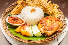 The word penyet from the name of this dish means to press or push, referring to the preparation method in which the chicken is pressed by a pestle in order to make the meat more tender. Tradisional Indonesian Cuisine Ayam Penyet Fried Chicken Served Stock Photo Picture And Royalty Free Image Image 86176155