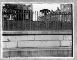 This is a natural photograph, no edition, no color enhancement. Bird Bath With Wrought Iron Fence Historic New England
