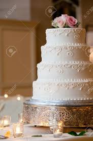 Hammered gold chargers with navy menus. A Multi Level White Wedding Cake On A Silver Base And Pink Flowers Stock Photo Picture And Royalty Free Image Image 13333678