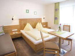 There is large green backyard with a barbecue area and a porch. Neue Zimmer Ferienwohnungen Wagrain Haus Katja