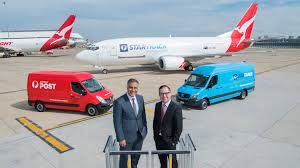 Brydie and her assistant hand the parcels to video: Australia Post And Qantas Announce Dedicated Freighter Fleet Post Parcel
