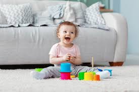 Premium Photo The Kid Plays On The Floor On A Light Carpet With Bright Toys Builds A Tower