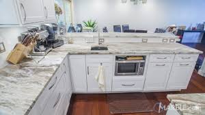 This New Modern Kitchen Features White Cabinets With Modern Sleek Hardware The Fantasy Brown Quartzite Gives The Kit Brown Kitchens Fantasy Brown Countertops