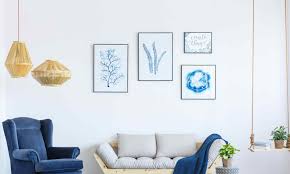 An ivory carpet and couch, taupe tables and walls, and purple accessories. 10 Trending Living Room Wall Decor Ideas 2021