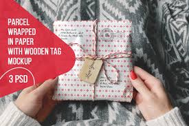 This free mockup offers square shaped tag with customizable ribbon and fabric textured background. Parcel Wrapped In Paper With Wooden Tag Mockup In Packaging Mockups On Yellow Images Creative Store