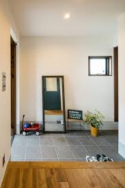 グレーのタイルに四角形の窓のあるシンプルな玄関 家のインテリア 模様替え 自宅で