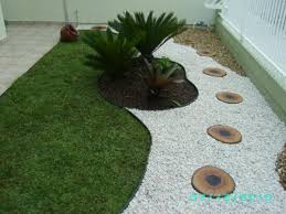 Add mulch and multicolored flowers to add color to a white house or stone wall. Garden Design Ideas With Pebbles