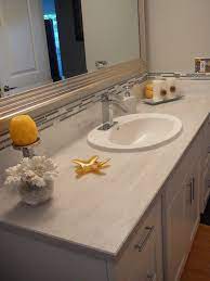 They come in a wide range of styles and colors and represent one of the most economical choices for bathroom countertops. White Shaker Vanity Micro Bevel Edge Laminate Counter Top Grey White And Yellow Color Scheme Laminate Countertops Bathroom Countertops Diy Countertops