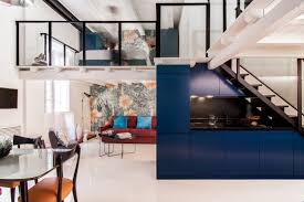 A bedroom mezzanine level with a double bed overlooks a cosy living room. Cool Interior Designs Illustrate The Versatility Of A Mezzanine Floor