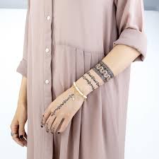 Aujourd'hui, il revient sur le devant de la scène avec des formes organiques modernes et des fleurs délicates. Faux Tatouage Mandala Black Et Bracelet Kolawi