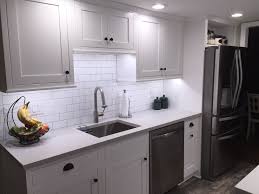Galley Kitchen With White Shaker Cabinets Subway Tiles Faux Wood Ceramic Tiles Stainless Steel Ap Galley Kitchen Design White Shaker Cabinets Galley Kitchen