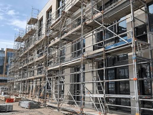 Scaffold erected around an occupied commercial office building during a facade renovation