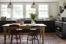 In terms of color harmony, the white flat panel cabinets of the kitchen space of this design contrasts with the dark brown finish on the cabinetry of the large kitchen island and the wooden floorboards. Dining Table Central In Kitchen Instead Of Island Kitchen Flooring Kitchen Inspirations Brick Kitchen