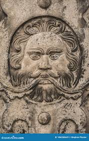 Stylised Bearded Man`s Face Carved into a Stone Wall Shot Straight on.  Stock Image
