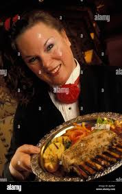 USA Alaska Waitress Kim Scanlan presents dinner at Corsair Restaurant in  Anchorage Stock Photo