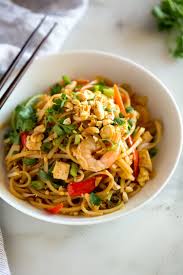 A Bowl Full Of Pad Thai With Rice Noodles Shrimp Chicken Tofu Green Onion Peanuts And Scrambled Egg Pad Thai Recipe Pad Thai Seafood Recipes