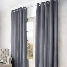 Spacious bedroom with large bed, dark curtains on window and potted plants on windowsill. Grey Arizona Blackout Eyelet Curtains Dunelm Curtains Dunelm Blackout Eyelet Curtains Teal Blackout Curtains