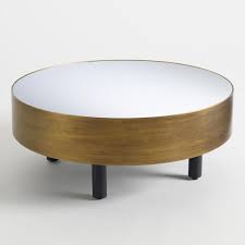The large gold mirror in this living room helps contrast the bold graphic patterns and complements the round coffee table. Cristelle Round Mirror Top Brass Coffee Table