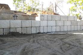 Concrete block retaining wall construction consists of number of phases including excavation, foundation soil preparation, retaining wall base construction, concrete block unit placement, grouting and drainage system installation. Large Concrete Block Retaining Walls Ibrs Inc