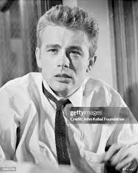 American actor James Dean leaning against a wall
