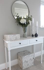 Grey Hallway With White Console Table Round Mirror And Faux Flowers With Candlesticks And Floral Boxe Hallway Table Decor White Console Table Hall Table Decor