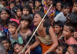 An akha woman wearing traditional costume with a headdress of silver and beads. A Rohingya Muslim Girl Cries As A Volunteer Beats Children With A Stick To Control A Crowd Waiting To Receive Meals Distributed Refugee Camp Bangladesh Refugee