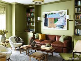 A Grey Blue Oushak Rug Compliments Olive Green Walls And Upholstery And A Brown Leather Sofa Adds Warmth And T Living Room Color Family Room Design Room Colors
