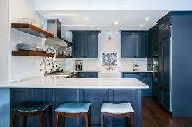A Blue Kitchen With White Walls Floating Shelves And Dark Wood Flooring Blue Kitchen Walls Wood Floor Kitchen Light Blue Kitchens