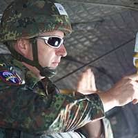 A German paratrooper packs his chute during a Joint