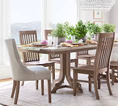 In a stark white room with a partially slanted ceiling, contrast is injected by way of a dark. Hayes Tufted Upholstered Dining Chair Pottery Barn