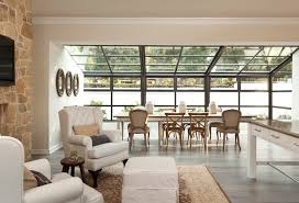 A chic country house sunroom with a daybed with a mattress and pillows, shades and a bread bowl is welcoming. Sunroom Dining Transitional Dining Room Gordon Gibson Construction