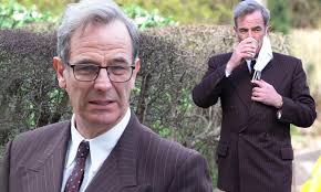 Robson Green removes his face mask to enjoy a sip of coffee