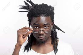 Handsome Dark Skinned Afro American Man With Dreadlocks And Glasses Is  Looking At Camera Stock Photo, Picture and Royalty Free Image. Image  151952114.