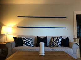 You can dress up this ordinary display with picture ledges. One Or Two Picture Ledge Shelves Above Sofa