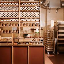Each shelf has an acrylic stop to avoid accidents of product sliding off the rack. Warm Hues And Central Oven Define Sofi Bakery In Berlin