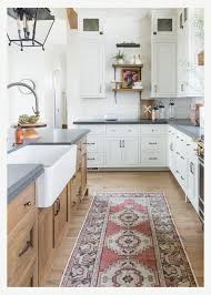 Beautiful White Kitchen With Light Wood Island Black Countertops And Vintage Runner Interior Design Kitchen Home Decor Kitchen Kitchen Interior