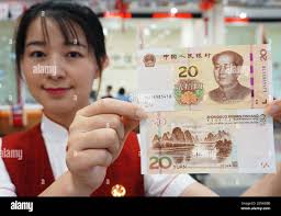 A Chinese employee shows 20-yuan banknotes of the 2019 edition of the fifth  series of the renminbi (RMB) at a bank in Hangzhou City, east China's  Zhejiang Province