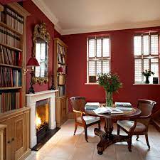 Minimalist kitchen with dining room in red tones with wooden and concrete details, dining table laid for two, chairs, parquet. Red Paint Room Ideas And Inspiration Architectural Digest