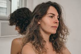 Una Hermosa Chica Con Pelo Rizado Mira Al Marco. Una Chica Sin Maquillaje.  Una Mujer Hermosa Y Natural. Minimalismo Foto de archivo