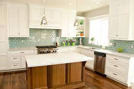 A stainless steel range and oven is flanked by classic white cabinets with nickel hardware. Best Backsplash Ideas For White Kitchen Cabinets