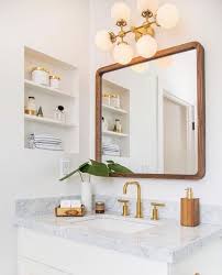 Mid Century Modern Inspired Bathroom With Marble Counter Tops Gold Faucets Wood Framed Square Mirror An White Vanity Bathroom Stylish Bathroom Chic Bathrooms