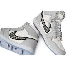 The shoe's italian leather upper appears in a mix of white and grey, with a dior oblique jacquard swoosh contrasting the side wall. Dior X Air Jordan 1 High Grailify