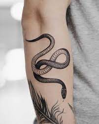 A Black Snake Tattoo On The Right Forearm Small Snake Tattoo Black Snake Tattoo Snake Tattoo Design