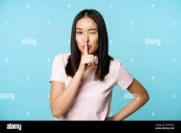 Souriant coquettish asiatique fille se précipitant, faisant silence tabou  geste, wencing et faisant le signe de hush, appuyez le doigt sur les  lèvres, debout sur bleu Photo Stock - Alamy