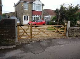 The large wooden gates mounted on stone pillars at the entrance to a modern country mansion. Diy Electric Gate Kit With Manual And Automatic Pedestrian Gate Youtube
