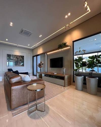 🏠 Sala contemporânea com iluminação embutida! 💡 A luz indireta realça o  piso de porcelanato e cria uma atmosfera acolhedora, enquanto a parede de  vidro amplia a luminosidade natural. ✨ Dica: Aposte